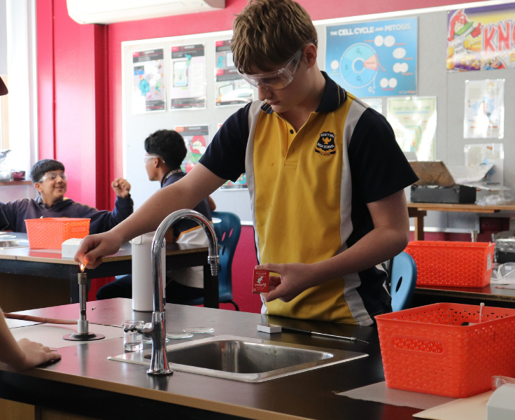 Image of a student using a bunsen burner in a science classroom